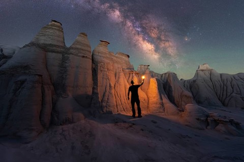A lone figure illuminates the magnificent sandstone formations of Goblin Valley State Park, Utah,