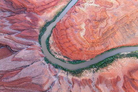 Aerial photograph of Rio San Juan meandering through the vibrant red rock formations and greenery