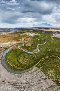 A breathtaking aerial drone photograph captures a winding river snaking through the rugged terrain