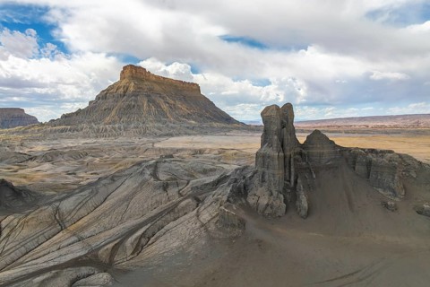 A breathtaking landscape featuring a towering desert mesa and striking rock formations under a