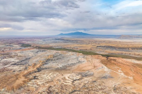A stunning aerial drone view capturing the vast, rugged landscape of Hanksville, Utah, highlighting