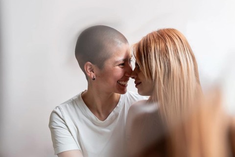A tender moment captured between a joyful lesbian couple, sharing a loving embrace. Their intimacy