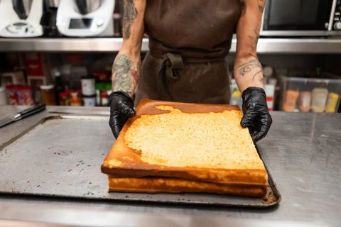 A baker in an Italian bakery handles freshly baked pastries The kitchen environment reflects
