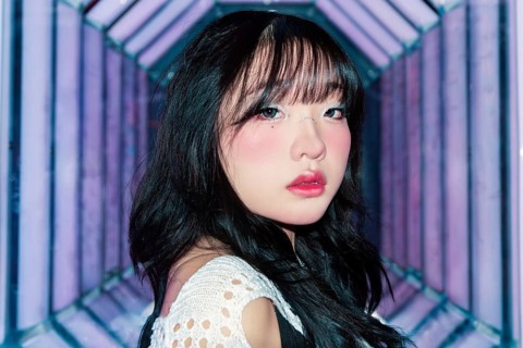 An Asian Gen Z girl with creative makeup explores a bright and vibrant arcade, embracing the lively