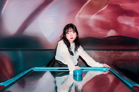 An Asian Gen Z girl enjoys a thrilling moment in an arcade, immersed in vibrant surroundings Her