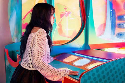 Young Asian Gen Z girl immersed in a vibrant arcade, enjoying the colorful lights and interactive