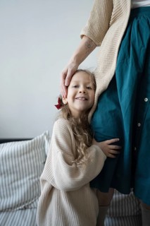 A young girl smiles while hugging her mother, showcasing a sense of warmth and security The scene