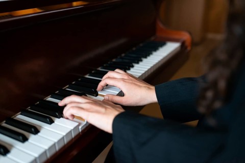 Close-up of a pianist's hands skillfully playing the piano, creating a serene and harmonious