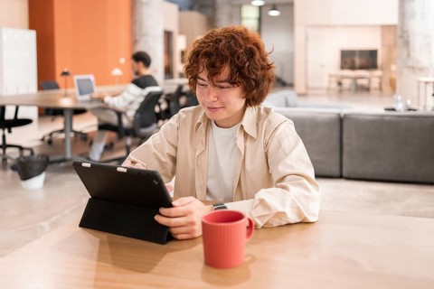 Young professionals working on laptops in a modern, open-plan office The focus is on collaboration,