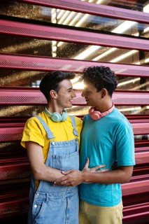 A joyful couple, wearing colorful casual outfits, share a loving moment. They look at each other