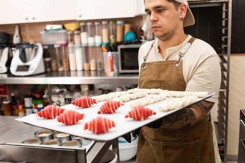 A skilled baker in a cozy Italian bakery prepares fresh pastries and bread The warm atmosphere
