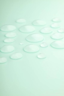 Droplets scattered on a smooth mint green surface, creating a calming and refreshing scene Soft