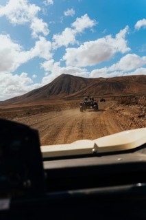 Lanzarote's rugged terrain from a buggy. Vast volcanic landscapes, scattered clouds and a scenic