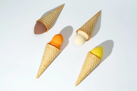 Four colorful cosmetic sponges creatively arranged in waffle cones, resembling ice cream scoops,