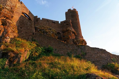 A striking view of the stone walls and towering structures of Chateau Polignac, glowing under the