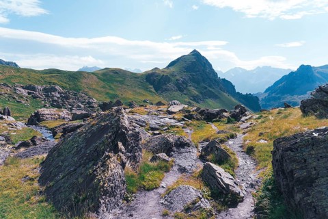 A scenic hiking trail winds through rocky terrain at the Ibones de Anayet in Huesca, Spain,