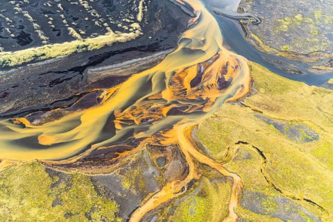 Captivating aerial photograph showcasing the intricate, golden-hued rivers weaving through the