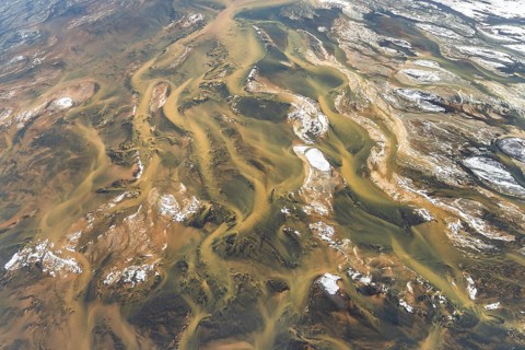 Aerial view of Iceland's rivers showcasing intricate textures and vibrant colors. The landscape