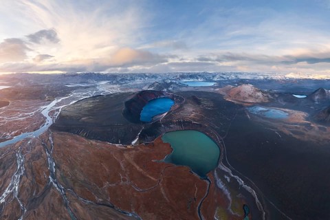 Captivating aerial view of Iceland's Highlands showcasing volcanic craters, vivid blue lakes, and