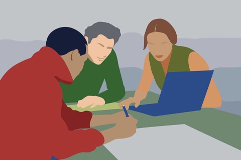 Two individuals are focused on a laptop while one person takes notes on paper in a collaborative