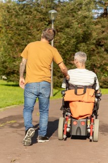 A thoughtful moment capturing a person walking with a friend in a wheelchair with a cerebral palsy