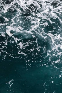 Moving seawater with white foam and dynamic texture. Waves and bubbles create a natural and
