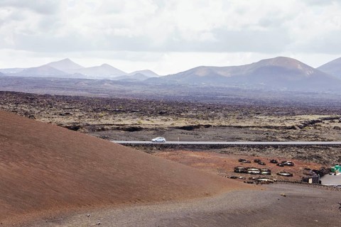 Deserted road in a volcanic landscape. The arid terrain and mountains on the horizon highlight the