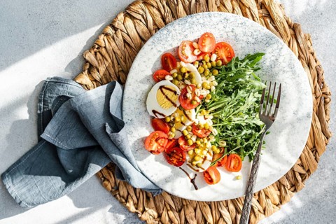 Delicious and nutritious keto salad featuring boiled eggs, fresh rocket, cherry tomatoes, canned