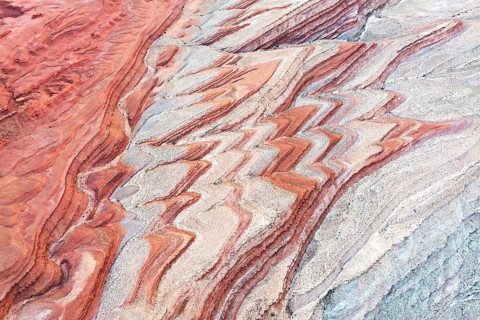Colorful sediment patterns unfold in an aerial view of the canyon landscape near the San Juan