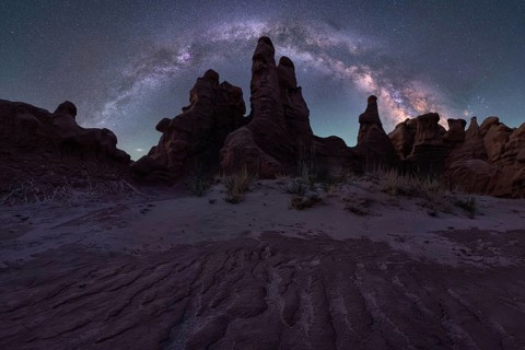 A mesmerizing night sky arches over unique sandstone formations in Goblin Valley State Park, Utah.