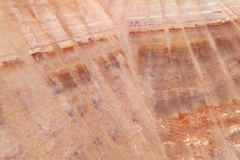 Aerial view of a multicolored sandstone exhibiting unique textures and earthy hues. The striations