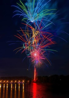 A stunning display of multicolored fireworks illuminates the night sky above the Ebro River, with