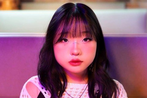An Asian Gen Z girl is immersed in the vibrant atmosphere of an arcade Her expression reflects the