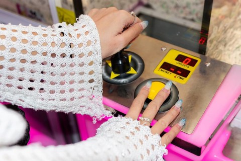 Gen Z girl enjoys her time at an arcade, using joystick controls for entertainment The vibrant