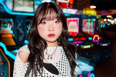 Asian Gen Z girl explores a vibrant arcade, surrounded by colorful lights and games Her expressive