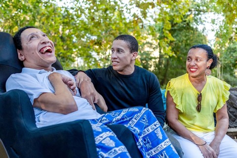 Spanish Cameroonian siblings outside, one with cerebral palsy, enjoying a sunny day together. This
