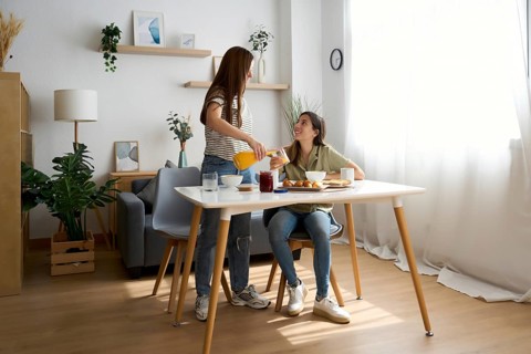A warm scene features a lesbian couple sharing a delightful breakfast in their cozy dining room The