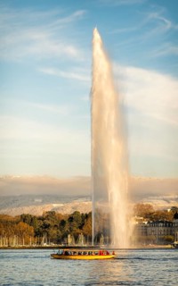 The iconic Jet d'Eau fountain in Geneva, Switzerland, captured during autumn with golden light, a