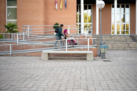 A college couple navigates a ramp on campus, highlighting accessibility The woman, in a wheelchair