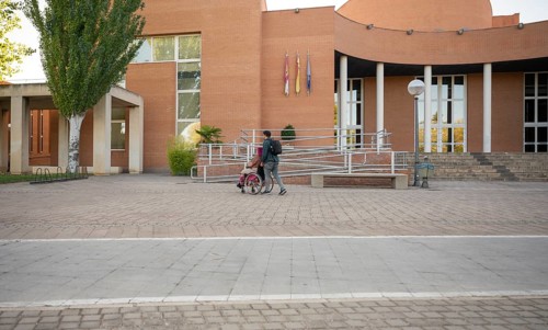 A couple traverses a college campus, highlighting accessibility and inclusion The woman, coping