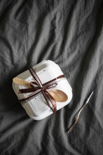Top view of an elegantly presented bento birthday cake, securely packaged in a white takeout box