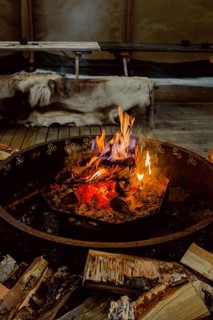 Warm and inviting fire in a Scandinavian setting in Swedish Lapland. Wooden logs are ready for