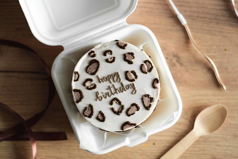 Top view of a stylish Bento birthday cake decorated with heart-shaped toppings, presented in a
