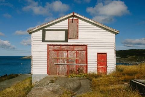 A weathered white and red storage building in Flatrock, Newfoundland & Labrador, Canada. The