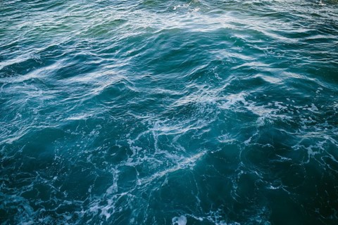 Close-up of dynamic ocean waves with swirling patterns and frothy textures at Flatrock,