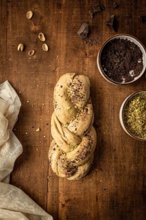 Top view of a freshly baked Bakbah bread adorned with chocolate shavings and pistachio bits, placed