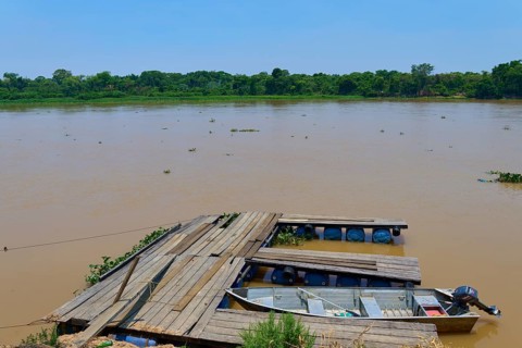 A wooden jetty on the riverbank with a boat tied just below the water surface, Porto Jofre,