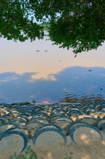 The riverbank is paved with stacked tires, shaded by treetops, Porto Jofre, Pantanal, Mato Grosso,