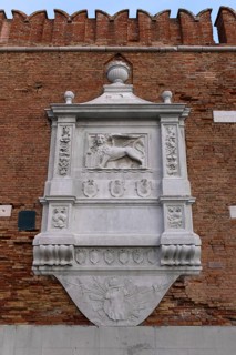 Heraldic relief of the city of Venice the Lion of St. Mark, on the wall of the Arsenal, weapons