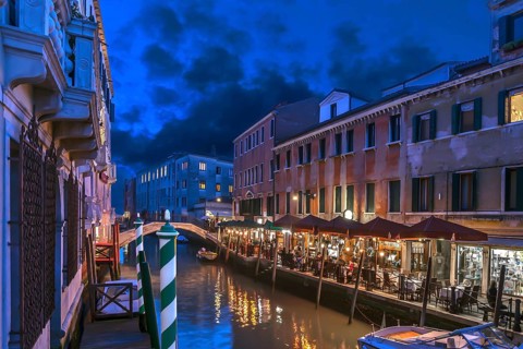 In the evening, illuminated restaurant on the canal, Venice, Veneto. italy